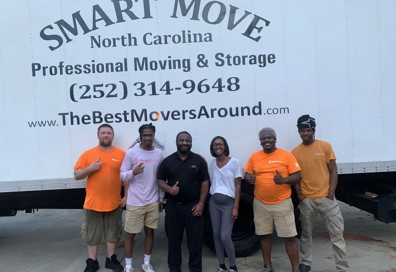A group posing together in front of a Smart Move truck