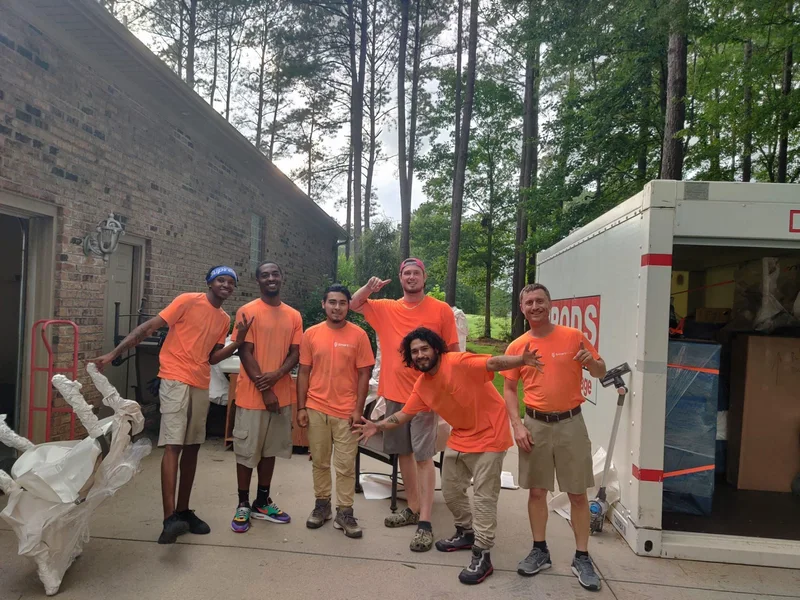 Smart Move crew posing on a driveway beside a moving truck