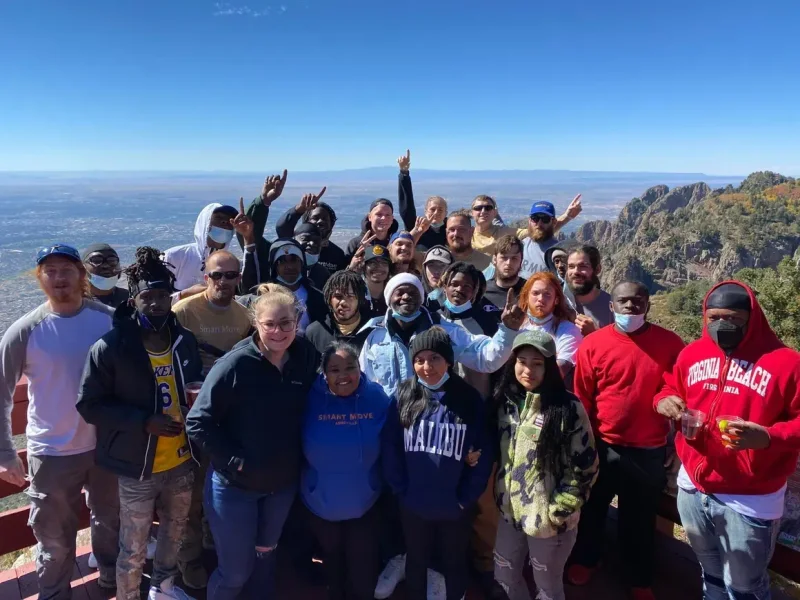 A large group gathered at a mountain overlook